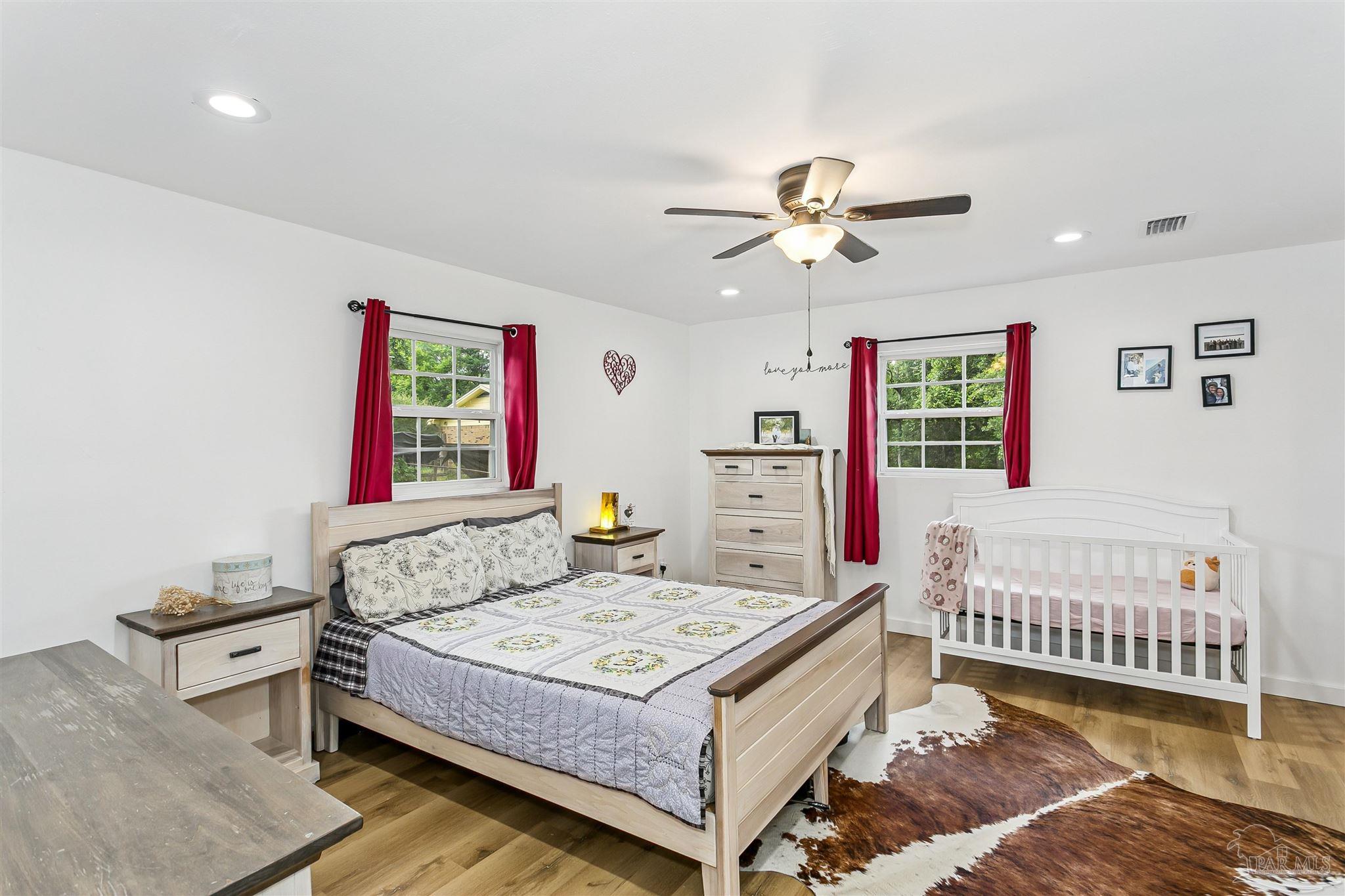 1095 River Annex Road Cantonment, FL 32533 - Photo 16 of 32 a bedroom with a bed dresser and a baby crib