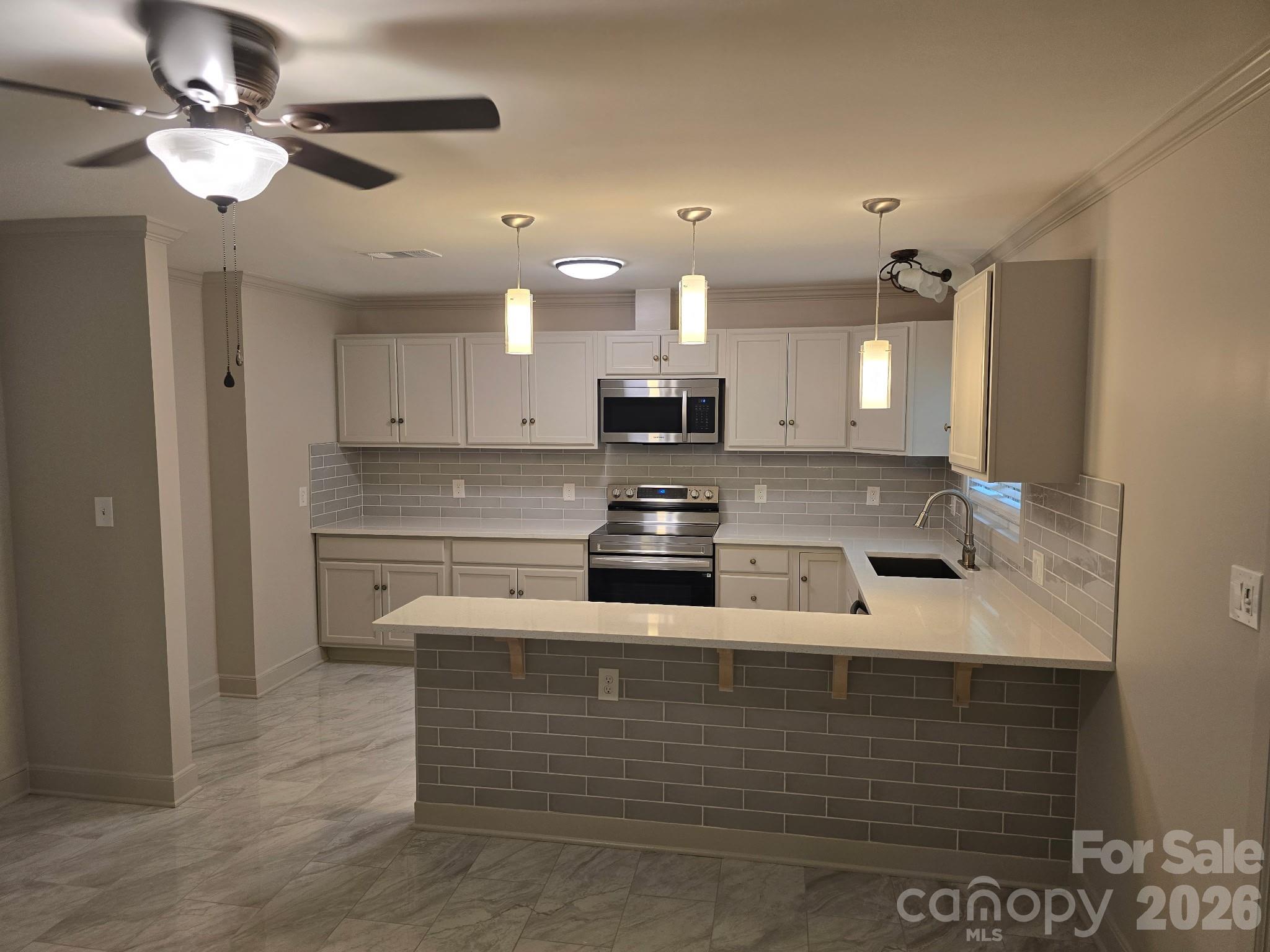 126 Sunset Drive Chester, SC 29706 - Photo 7 of 31 a kitchen with kitchen island stainless steel appliances a stove refrigerator and cabinets