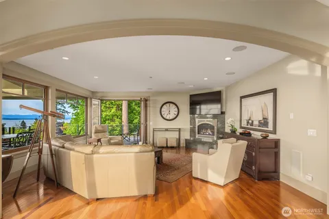 a living room with fireplace furniture and a large window