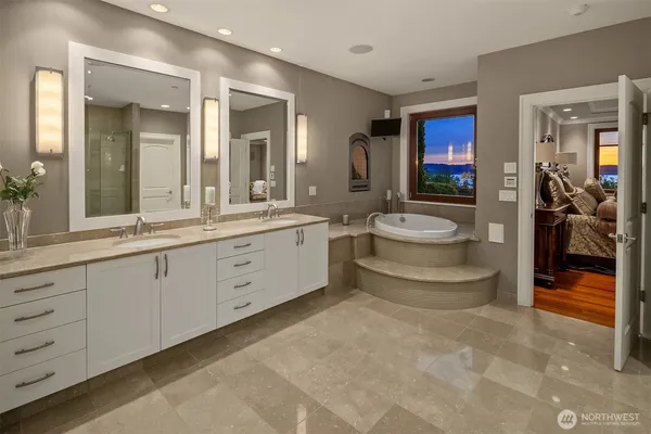 a spacious bathroom with a double vanity sink a large mirror and shower