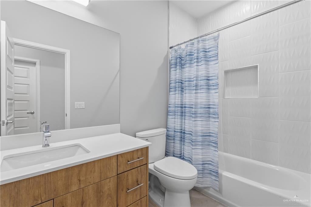 2612 Mockingbird Road, Unit 4 Weslaco, TX 78596 - Photo 7 of 11 a bathroom with a sink a toilet and shower
