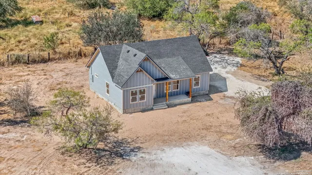 an aerial view of a house with a yard and lake view