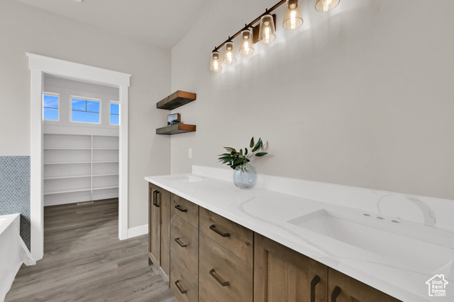 658 West 500 South Logan, UT 84321 - Photo 5 of 25 Full bath with double vanity, light wood-type flooring, a bathtub, and a walk in closet