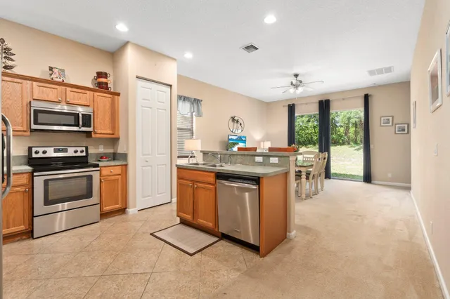 a kitchen with stainless steel appliances kitchen island granite countertop a stove a sink and a refrigerator