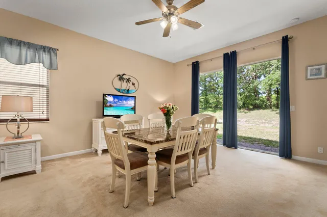 a dining room with furniture a flat screen tv and a large window