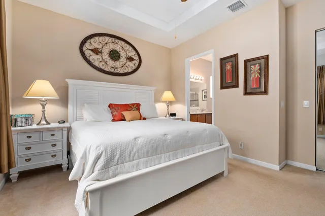 a bedroom with a bed and a lamp on dresser