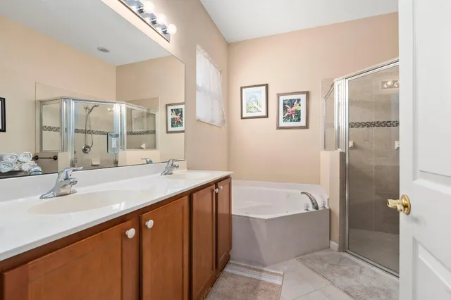 a bathroom with a tub a sink and mirror