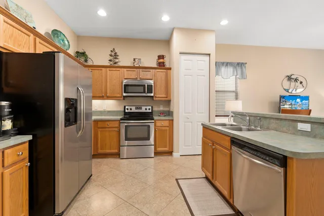 a kitchen with stainless steel appliances granite countertop a refrigerator sink and stove