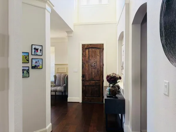a view of a hallway with wooden floor and furniture