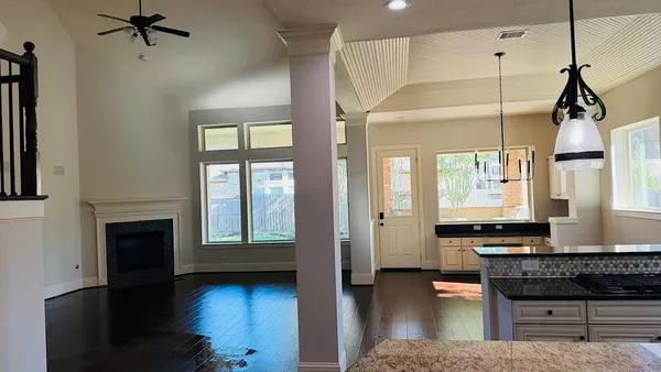 an empty room with ceiling fan and window