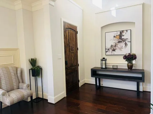 a view of a hallway with wooden floor and furniture