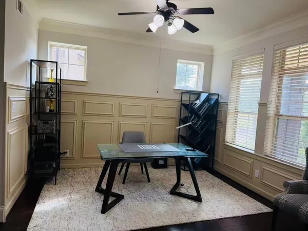 a view of a workspace with furniture and a window