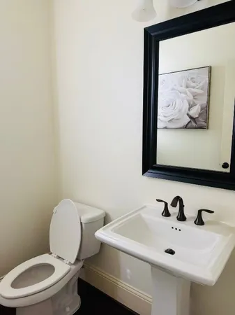 a bathroom with a toilet sink and mirror