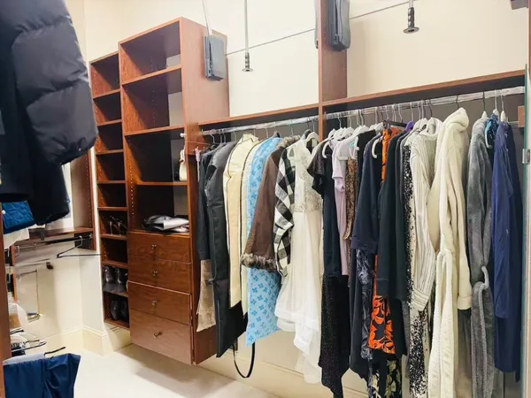 a view of walk in closet with clothes and shoes