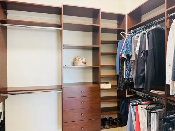 a view of walk in closet with clothes and shoes
