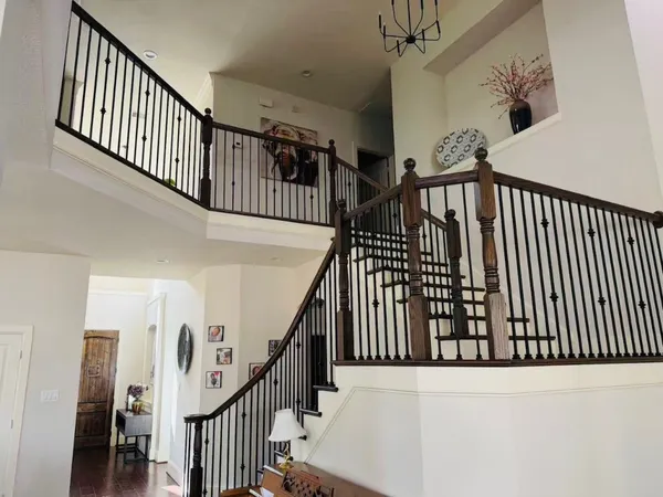 a view of staircase with lots of frames on wall and wooden floor