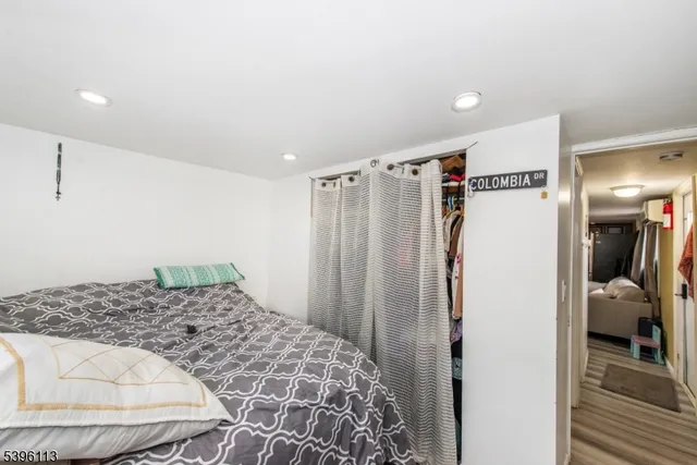 a bedroom with a bed and a refrigerator