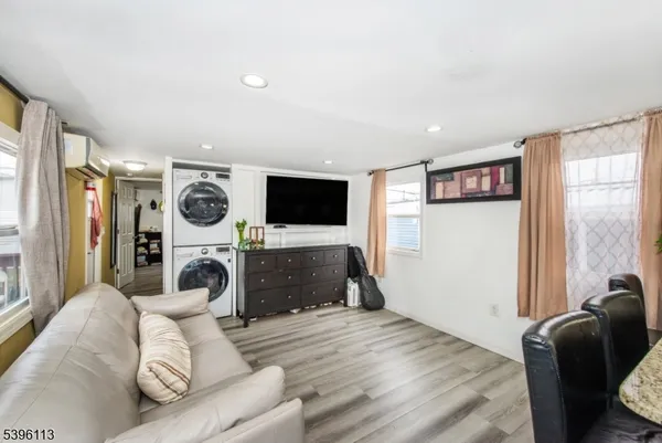 a living room with furniture and a flat screen tv with kitchen view