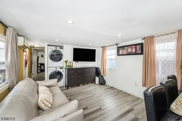 a living room with furniture and a flat screen tv with kitchen view