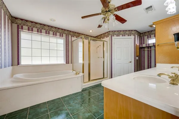 a spacious bathroom with a tub shower and a sink