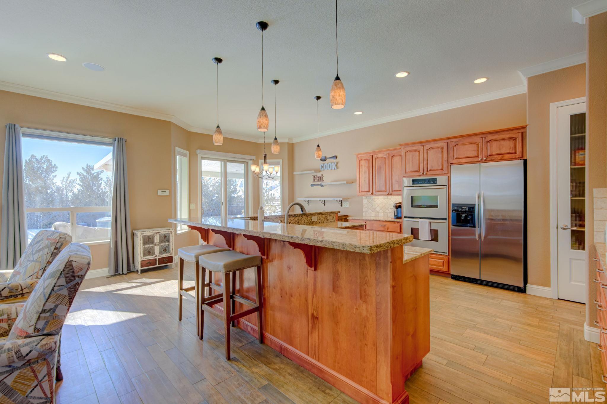 1122 North Fork Trail Minden, NV 89423 - Photo 11 of 40 a kitchen with stainless steel appliances granite countertop a table chairs and a refrigerator