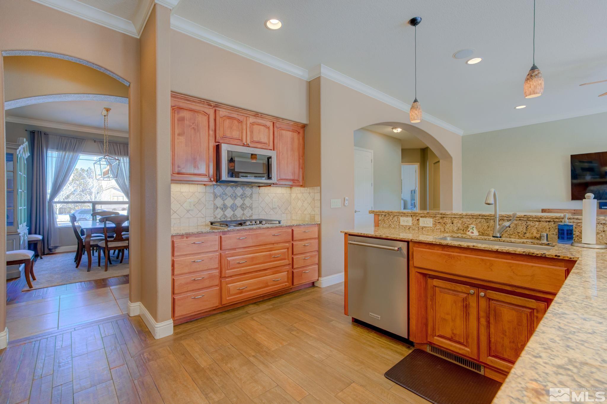 1122 North Fork Trail Minden, NV 89423 - Photo 14 of 40 a kitchen with stainless steel appliances granite countertop a sink a stove and a wooden floors