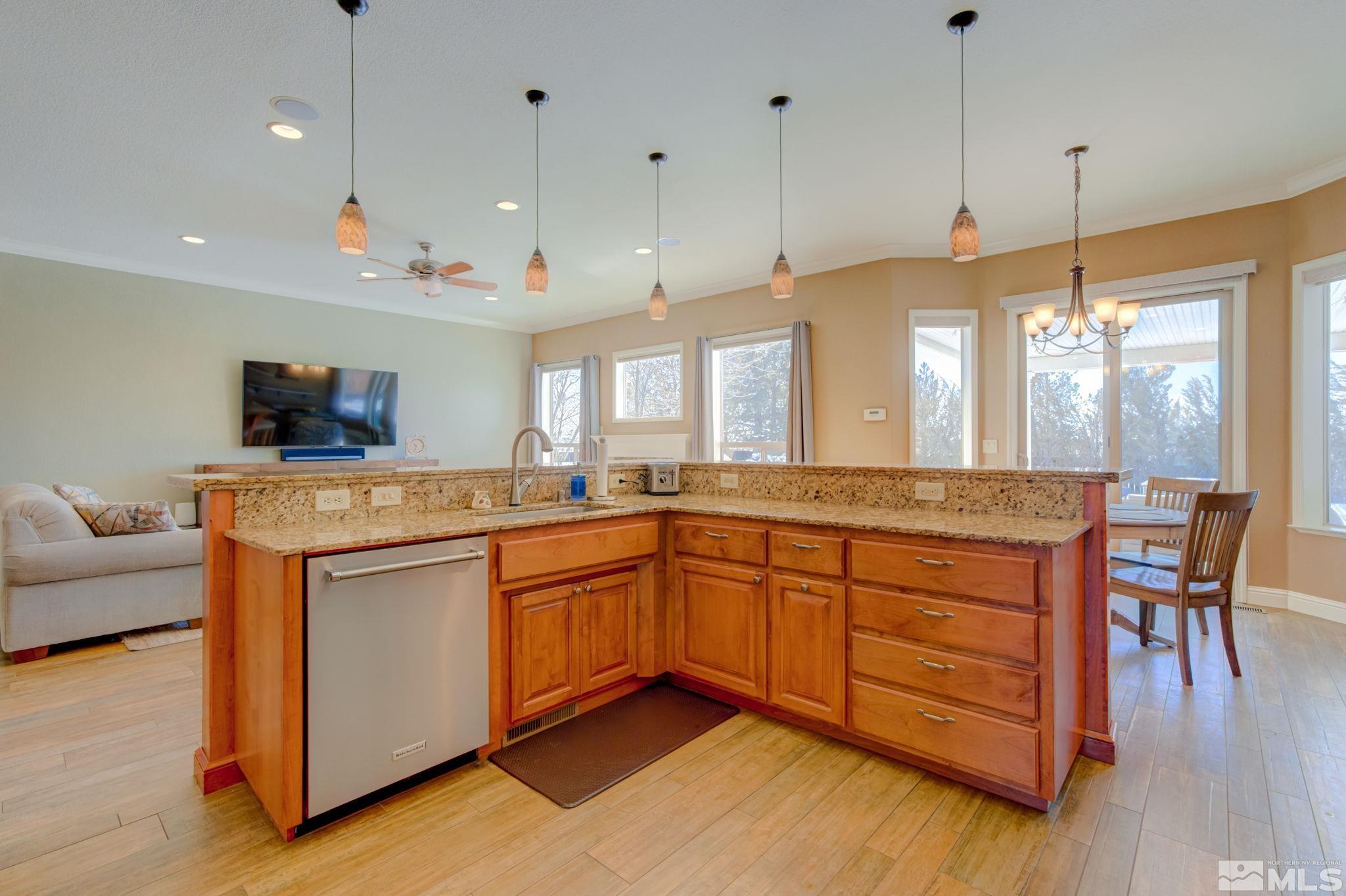 1122 North Fork Trail Minden, NV 89423 - Photo 15 of 40 a open kitchen with stainless steel appliances granite countertop a stove and a wooden floors