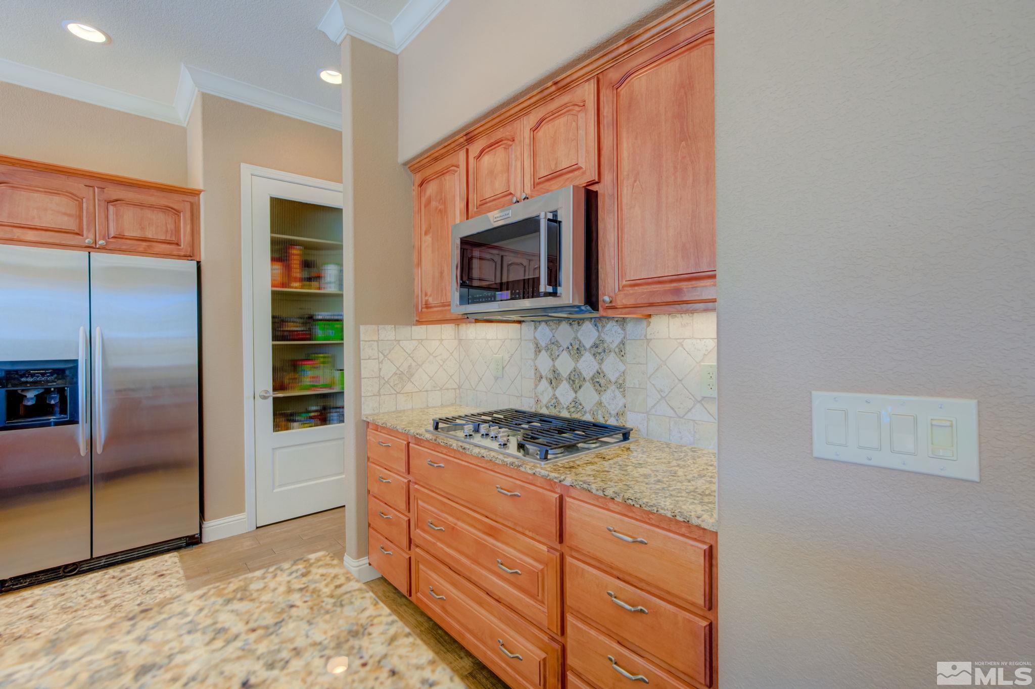 1122 North Fork Trail Minden, NV 89423 - Photo 16 of 40 a kitchen with stainless steel appliances granite countertop a stove a microwave and a refrigerator