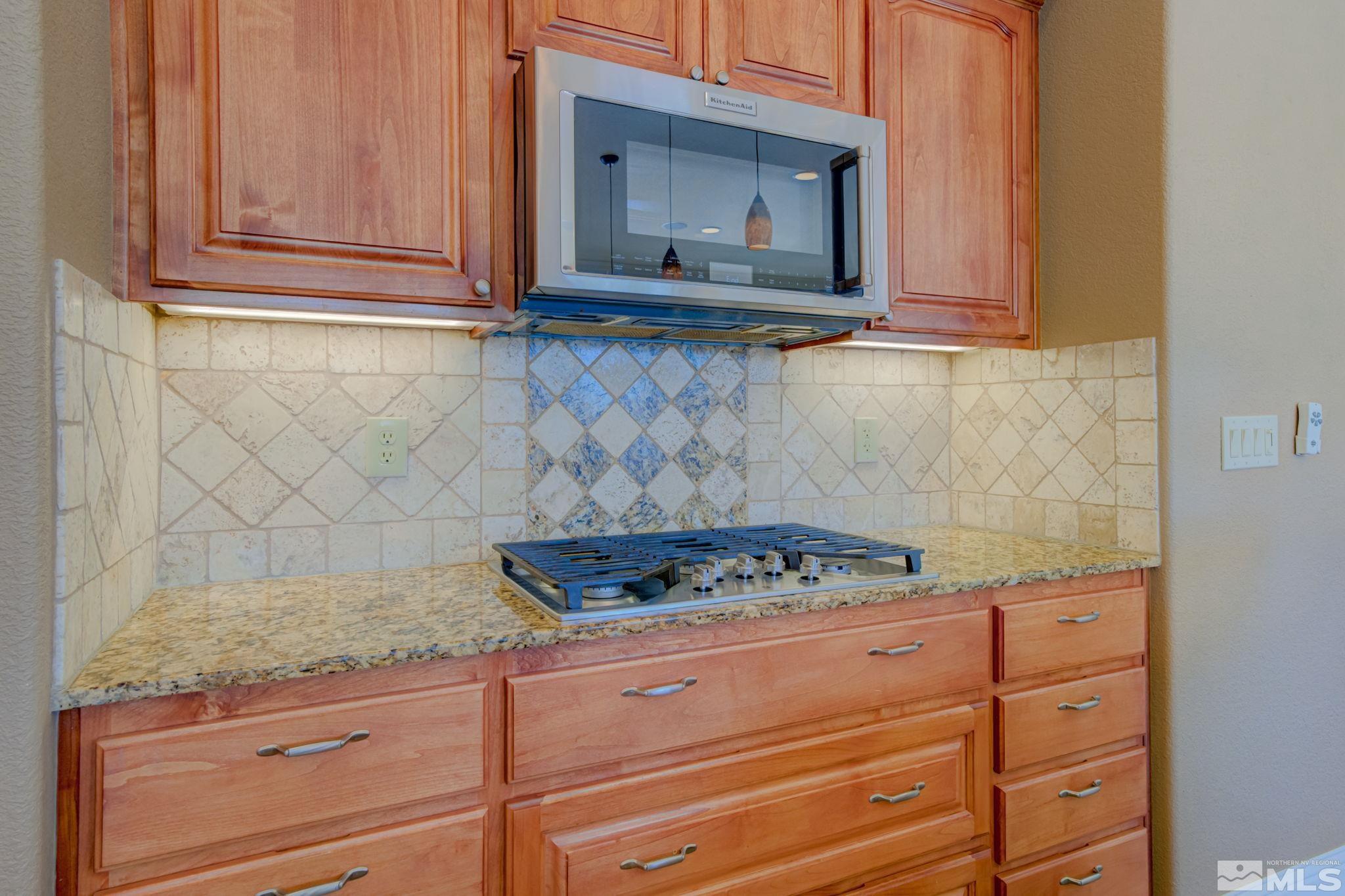 1122 North Fork Trail Minden, NV 89423 - Photo 17 of 40 a kitchen with granite countertop white cabinets and stainless steel appliances