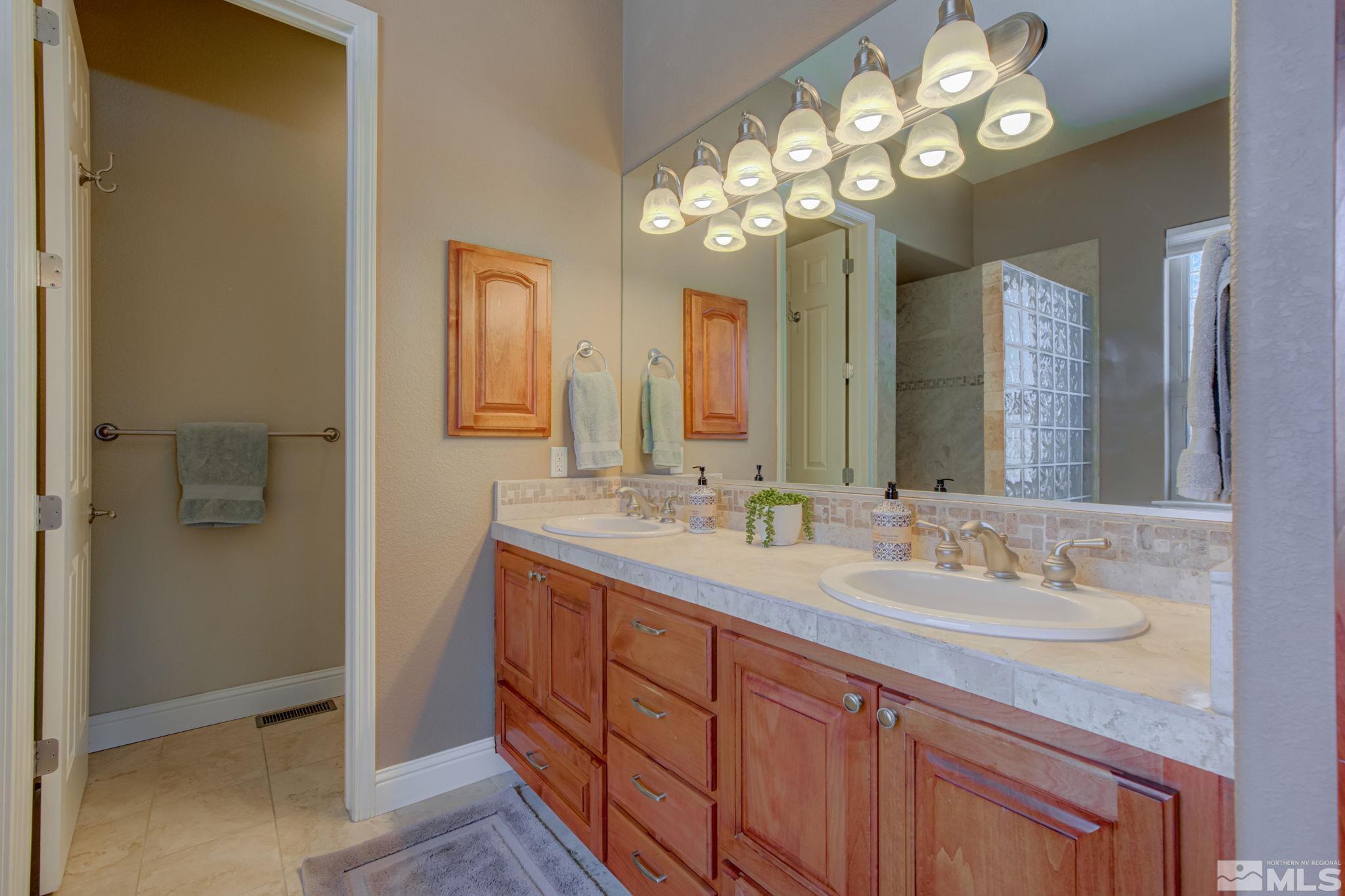 1122 North Fork Trail Minden, NV 89423 - Photo 27 of 40 a spacious bathroom with a granite countertop sink a large mirror and a shower