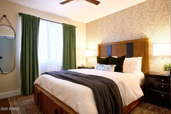 a bedroom with a bed a mirror and a window