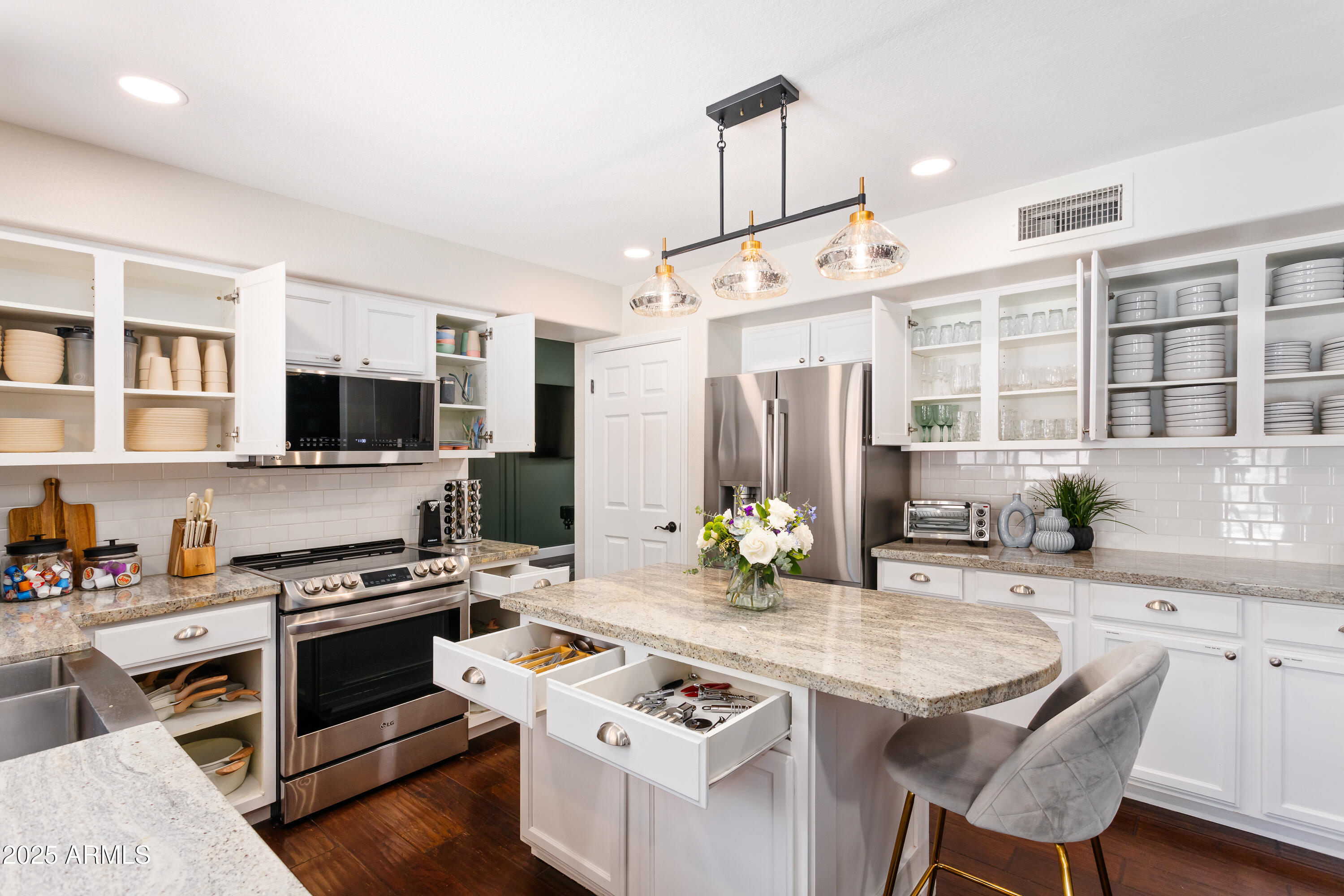 20619 North 16th Way Phoenix, AZ 85024 - Photo 46 of 64 a kitchen with stainless steel appliances kitchen island granite countertop a stove and a sink