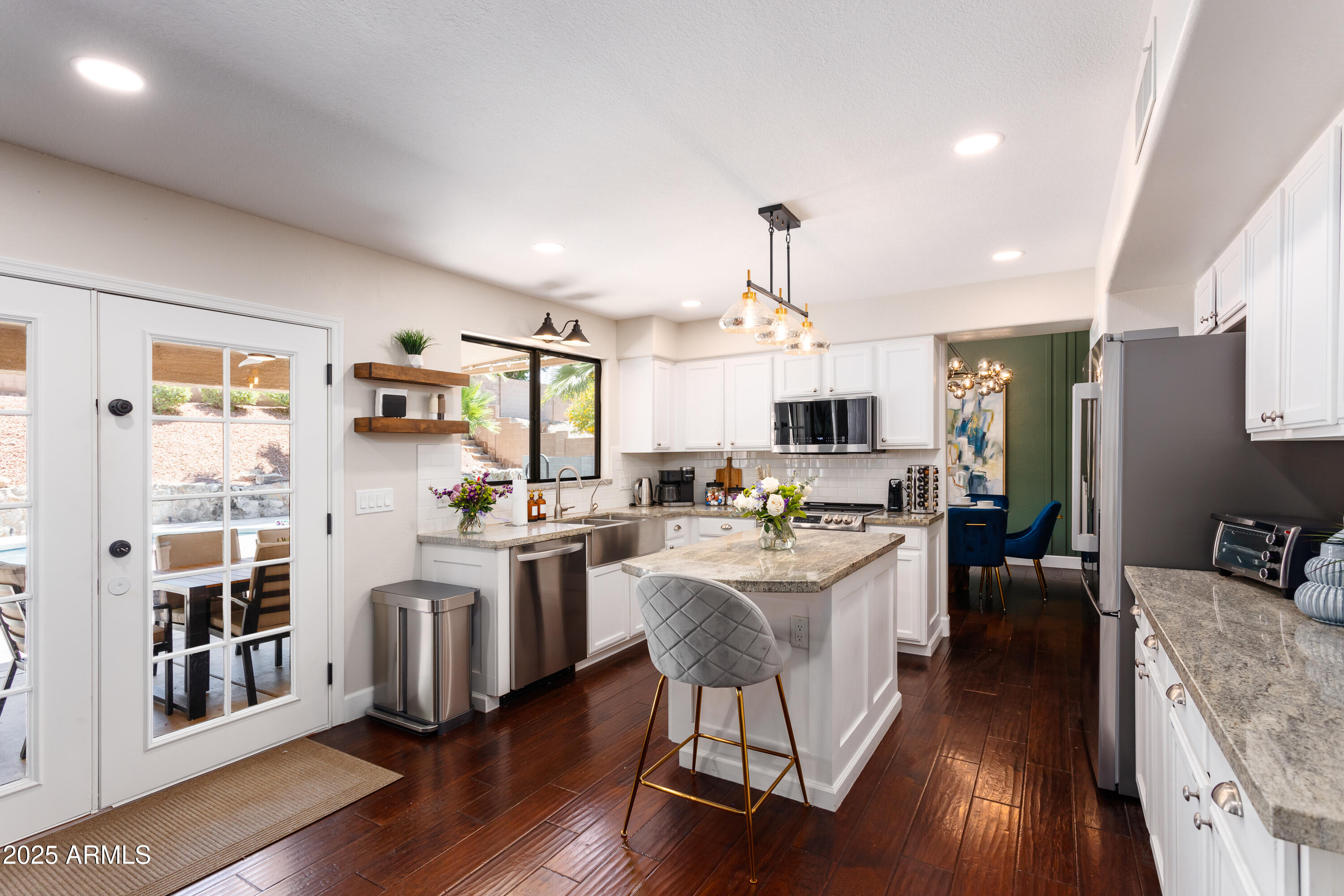 20619 North 16th Way Phoenix, AZ 85024 - Photo 9 of 64 a kitchen with stainless steel appliances kitchen island granite countertop a stove top oven a sink dishwasher a dining table and chairs with wooden floor