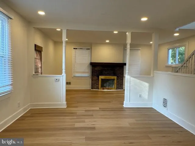 a view of empty room with wooden floor and fireplace