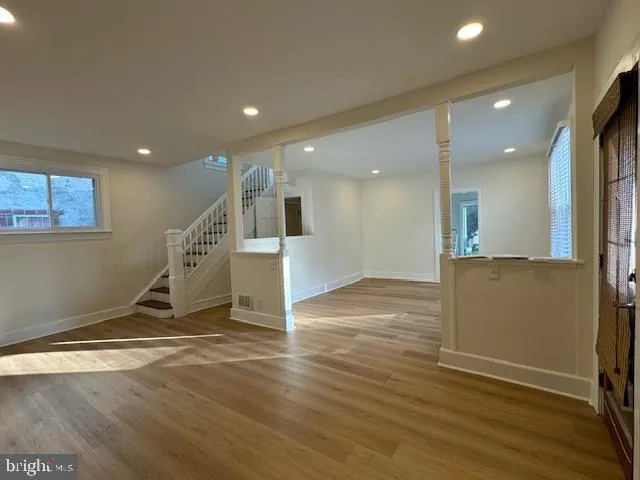 a view of a livingroom with wooden floor and stairs