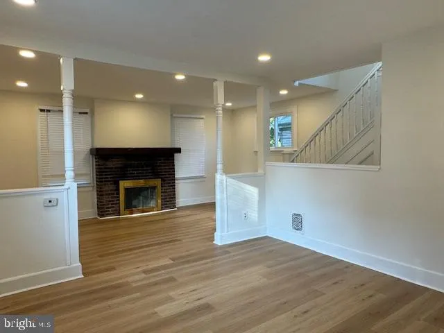 a view of a livingroom with wooden floor and staircase