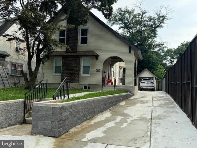 a view of a house with a yard potted plants and a large tree