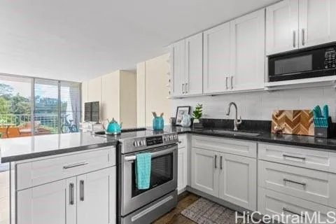 a kitchen with stainless steel appliances granite countertop a sink a stove and a microwave