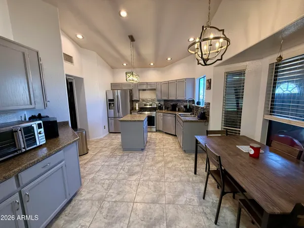 a view of a dining room with furniture a chandelier and wooden floor