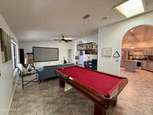 a living room with furniture pool table and flat screen tv