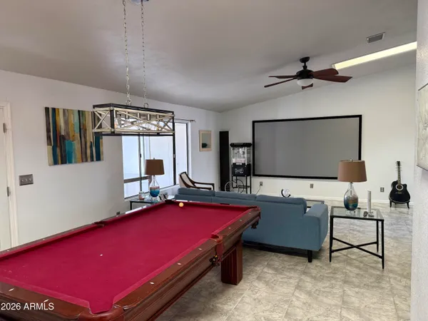 a living room with furniture pool table and flat screen tv