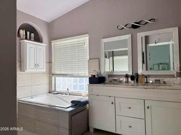 a bathroom with a granite countertop sink and a window