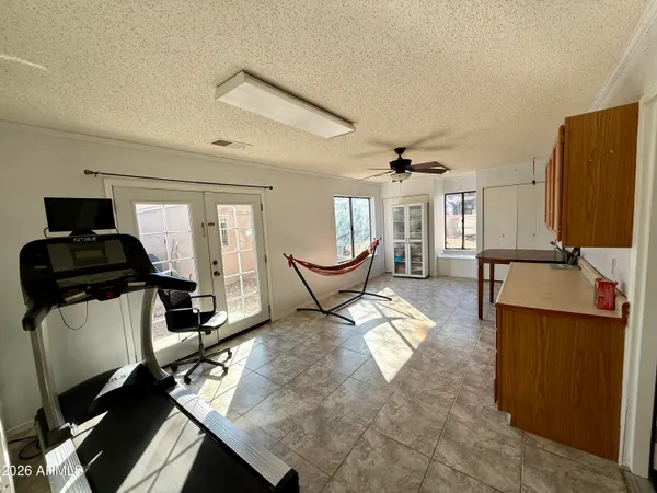 a living room with furniture a flat screen tv and a refrigerator