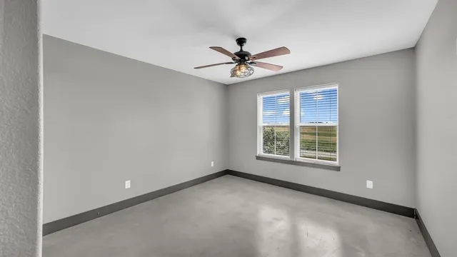an empty room with a window and a fan