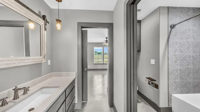 a bathroom with a tub sink and mirror