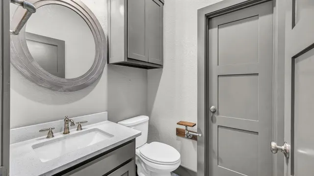 a bathroom with a toilet a sink and mirror