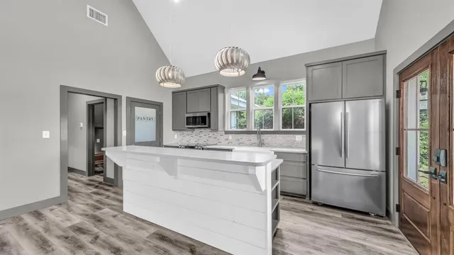 a kitchen with kitchen island white cabinets and stainless steel appliances