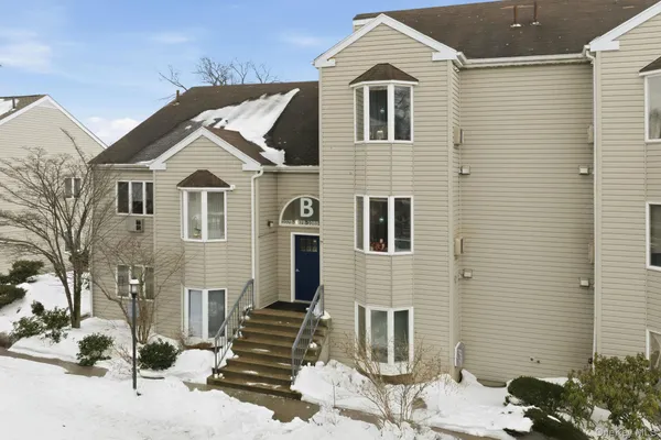 a view of a white house with a yard and large tree
