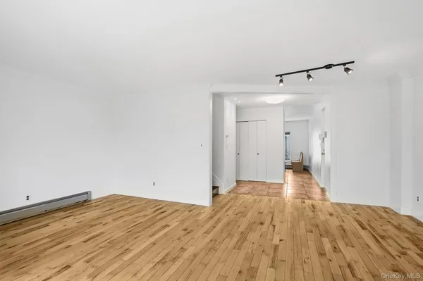 a view of a room with wooden floor and white walls