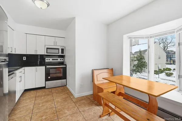 a kitchen with stainless steel appliances a stove a sink and white cabinets